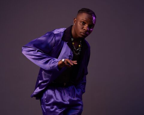 Promotional photo for "Wetin No Good (Remix)" in collaboration with Eltee Skhillz and DanDizzy, which sees Idahams posing at a photo studio with a purple background, and he's wearing velvet purple suit.