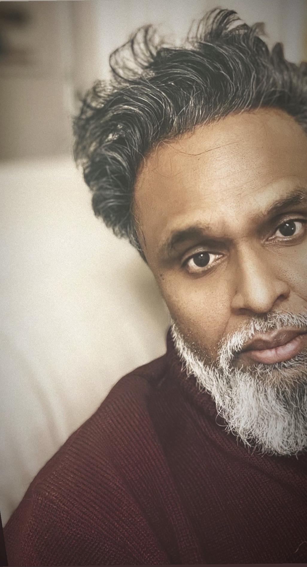 Promotional photo for "For Better or For Worse" featuring YBTB which sees a headshot of Chin Injeti, but only half his face in a selfie. He is wearing a burgundy jumper that makes his white beard look brighter.