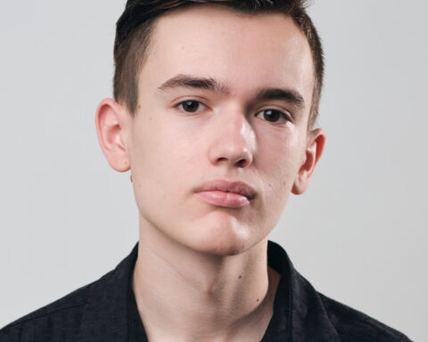 Promotional photo for "Party In The U.S.A." in collaboration with Myah Marie which is a headshot photo of Night Acclaim wearing a black shirt, that matches his short dark hair.